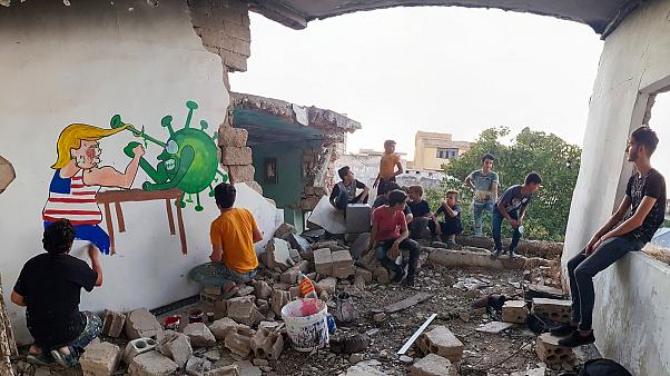 ترامب ضد كورونا على جدران مبنى مدمر في سوريا